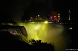 Niagara Falls at night light show in yellow with Skylon Tower in Canada visible.jpg
